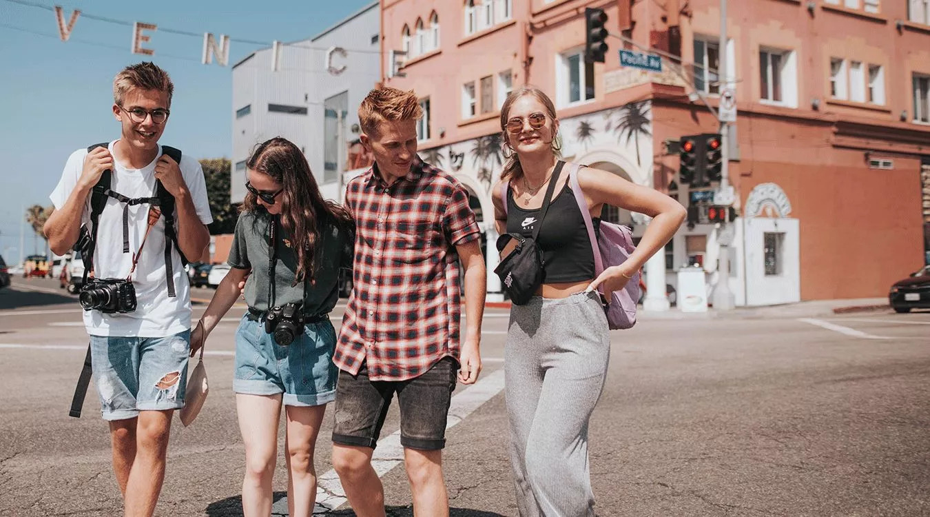 Four people walking across the road in Venice Beach, California.