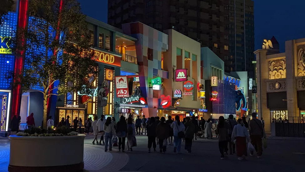 Lit up signs of Universal CityWalk Osaka shopping centre at night.