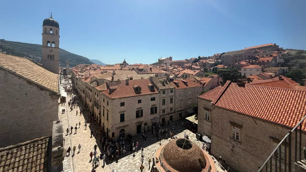 Stone buildings with red rooves and a bell tower in Dubrovnik's Old Town.