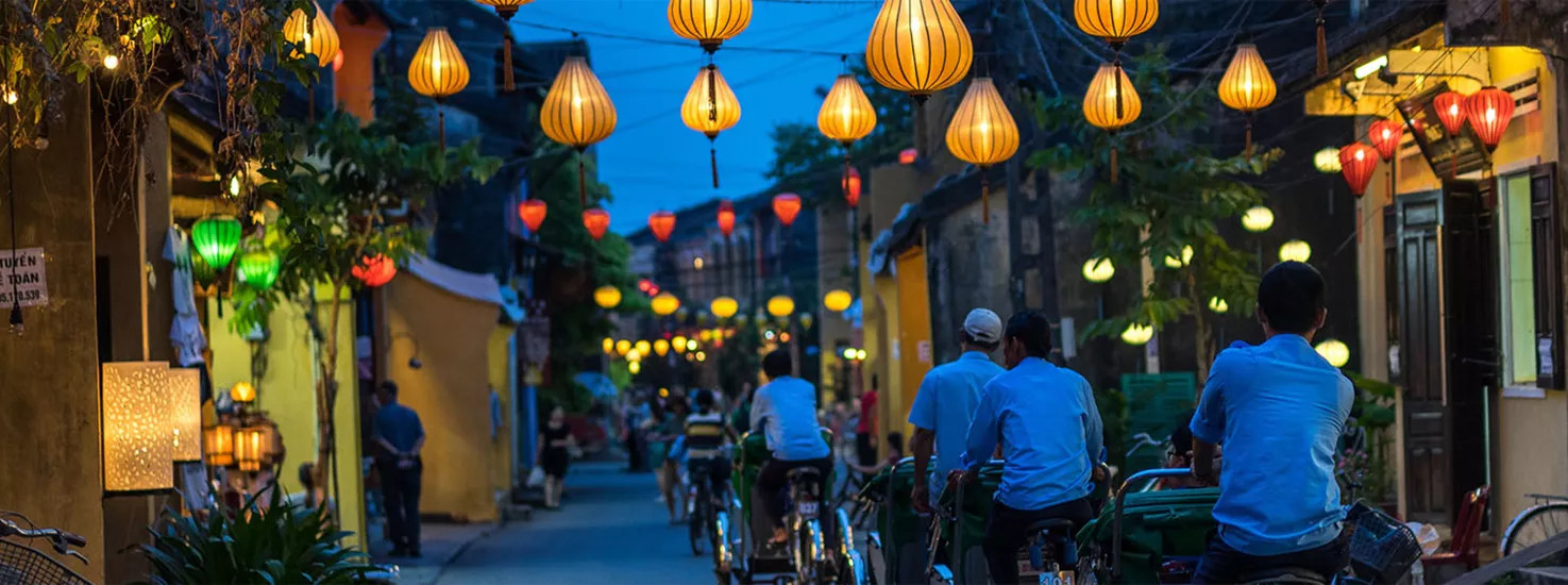 Locals cycle down the lantern lit streets of Hoi An in Vietnam.