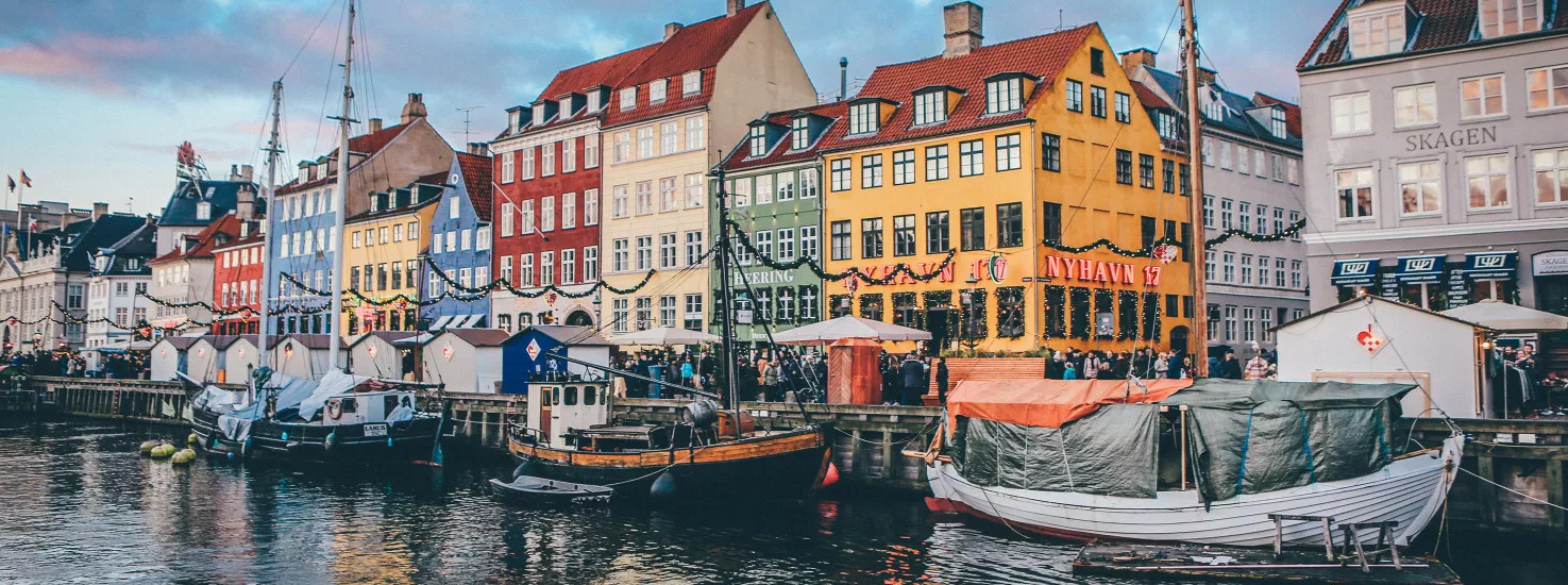 Boats and colorful houses line the docks of Nyhavn harbour in Copenhagen.