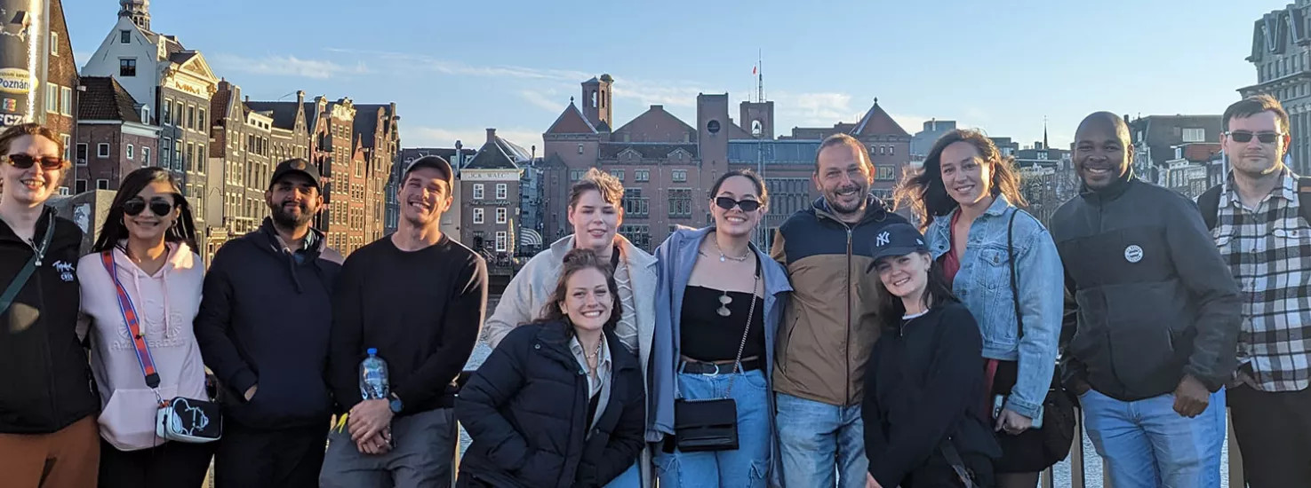 A group of Topdeck travellers posing for a photo together in Amsterdam.