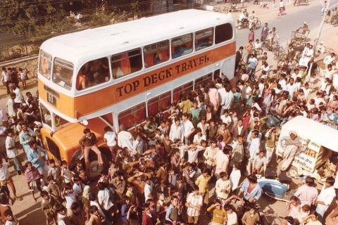 A crowd surrounding a Topdeck bus