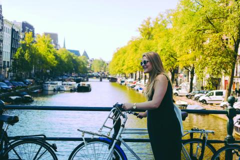 A woman parking her bike next to the canal 
