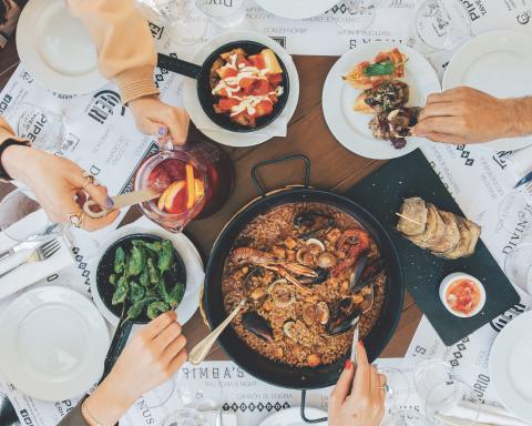 plates of food with people serving themselves food from different dishes