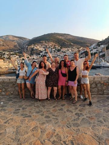topdeckers throwing their hands in the air in Hydra, Greece