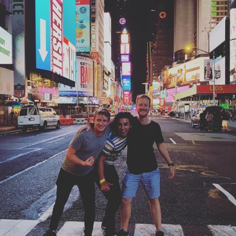 Three men embracing in Times Square