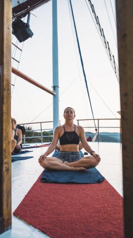 A person doing yoga on a boat