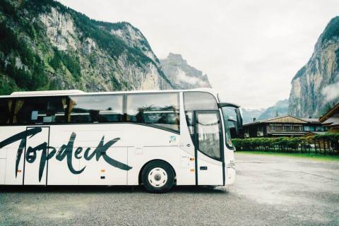 A topdeck coach with mountains in the back