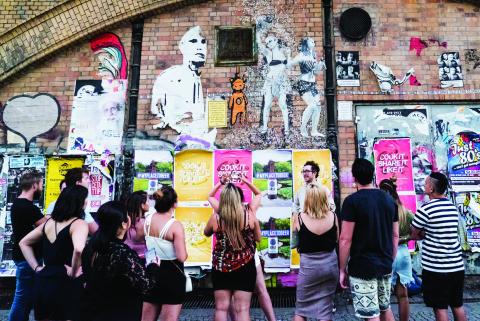 People looking at street art on a wall in Berlin