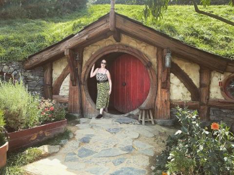 A woman standing in front of house featured in The Hobbit