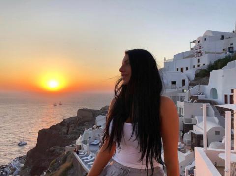 Woman standing in front of a greek sunset