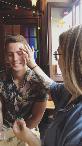 Woman applying glitter to a man's face