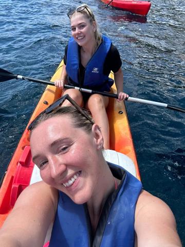 A selfie of two girls in an orange canoe boat