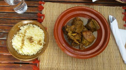 Cous cous in a bowl next to a bowl of other food