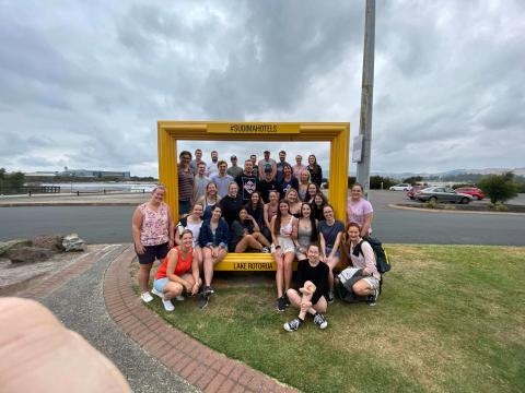 A group of people surround a large frame 