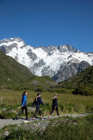 Three women walking with mountains in the back