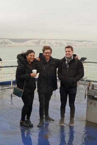 A woman and two men standing on a boat