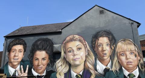 A painting on a building of the Derry Girls cast