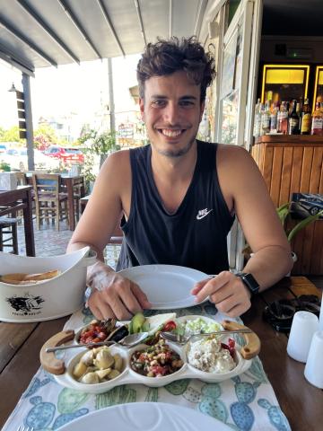 Man smiling in front of a plate of food