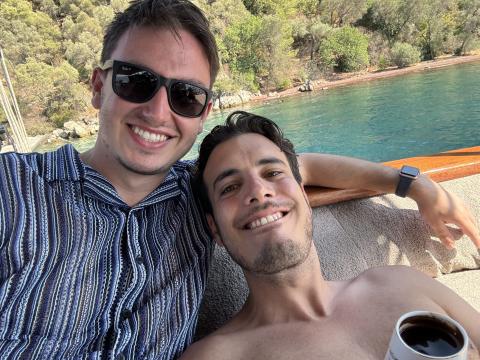 Selfie of two men on a boat, smiling