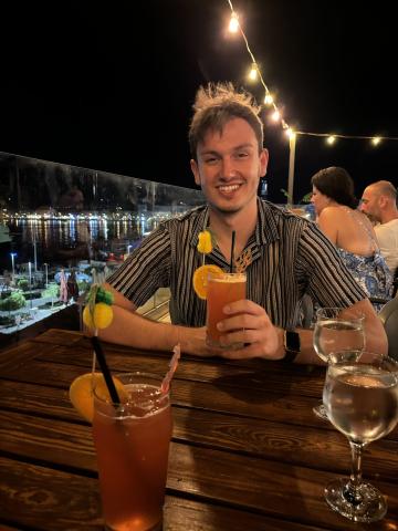 Man smiling holding a cocktail