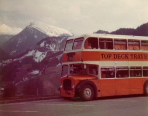 The topdeck bus in Switzerland, next to Swiss mountains