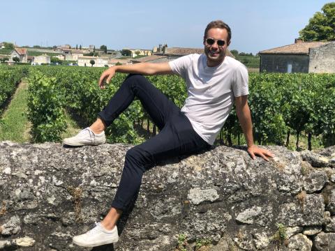 A man sitting on a wall in the sun