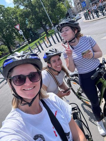 Three women on bikes with helmets on