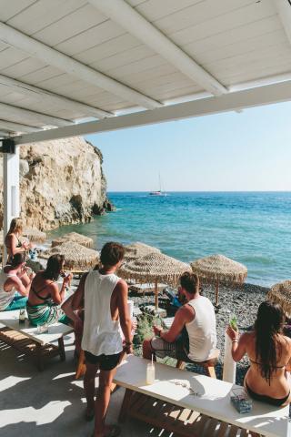 People relaxing with drinks by the beach
