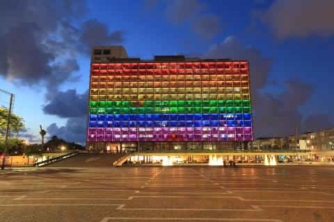 A lit up rainbow building in Tel Aviv