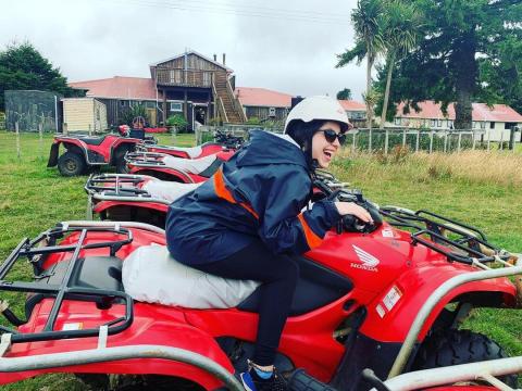 A woman sitting on a red and white quad bike