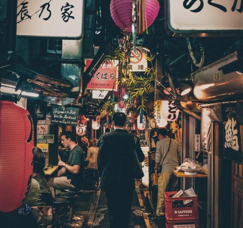Japan alleyway full of restaurants, people eating and signs