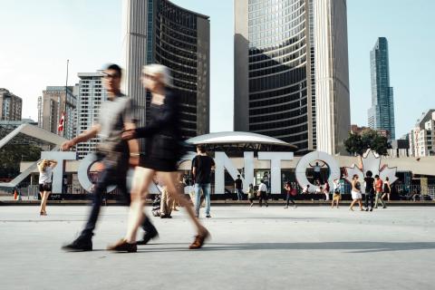 People walking past a sign in Toronto