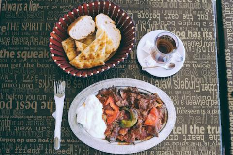 A plate of İskender Kebab, Turkish tea, and bread