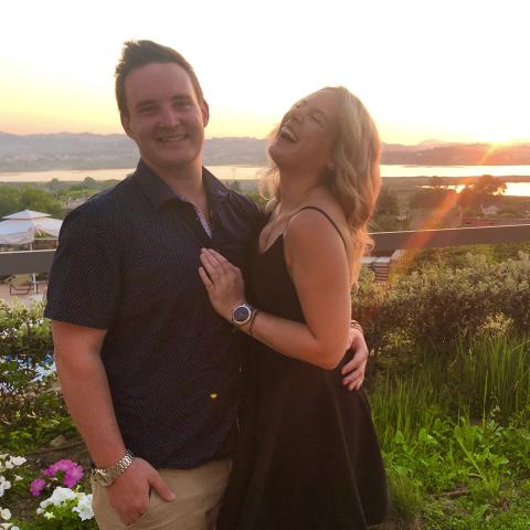 man and woman embracing in front of a sunset