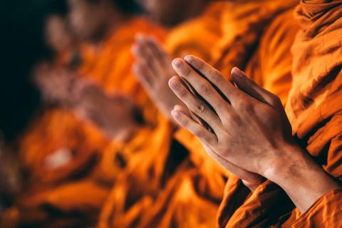 A close up of monks hands praying