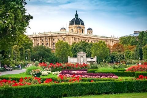 A large building behind a beautiful garden 