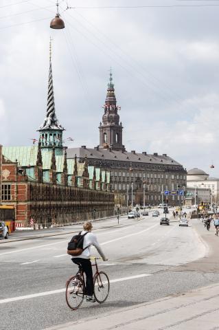 A person cycling down a street in Copenhagen