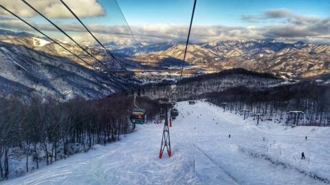 Ski lift in Hakuba, with snowy mountains in the back