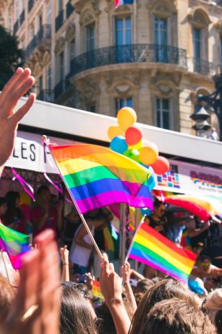Small pride flags in the sky in a crowd of a pride parade