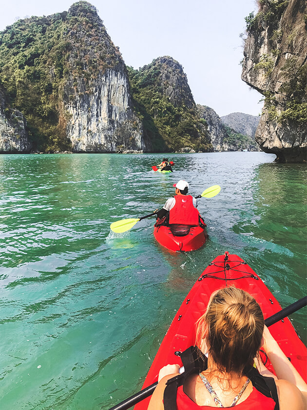 Topdeck travelers kayaking across Halong Bay.