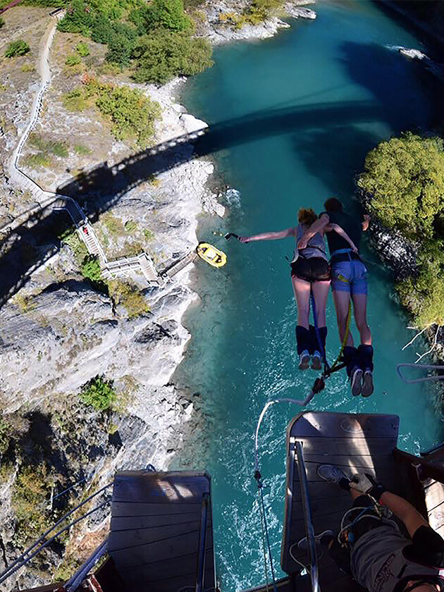 Topdeck travelers bungy jumping over river in Queensland.