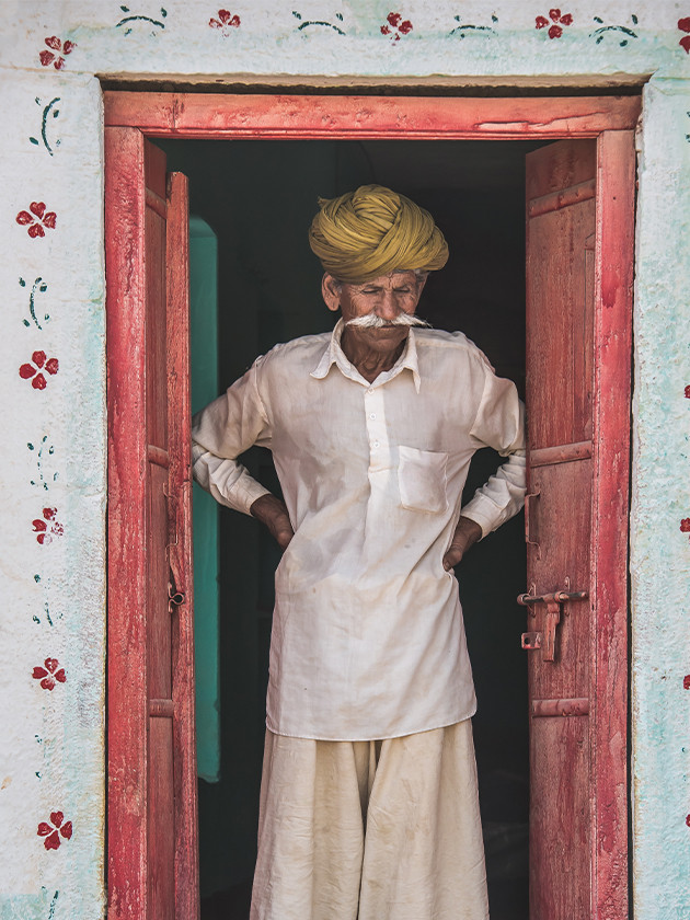 Indian man standing in doorway.