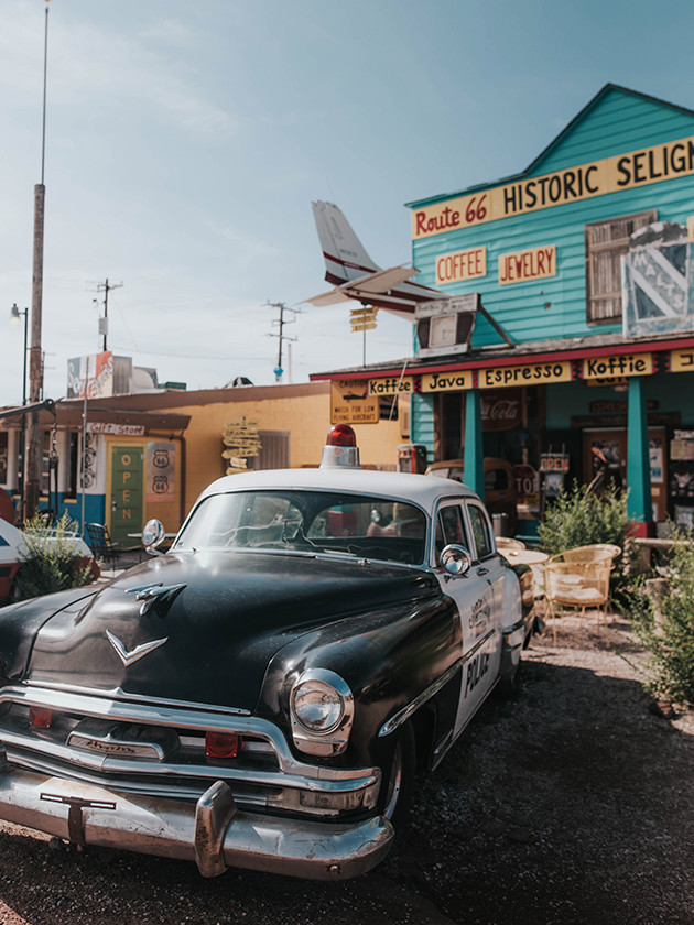 An old American police station wagon is parked in front of a general store in Seligman Arizona along route 66.