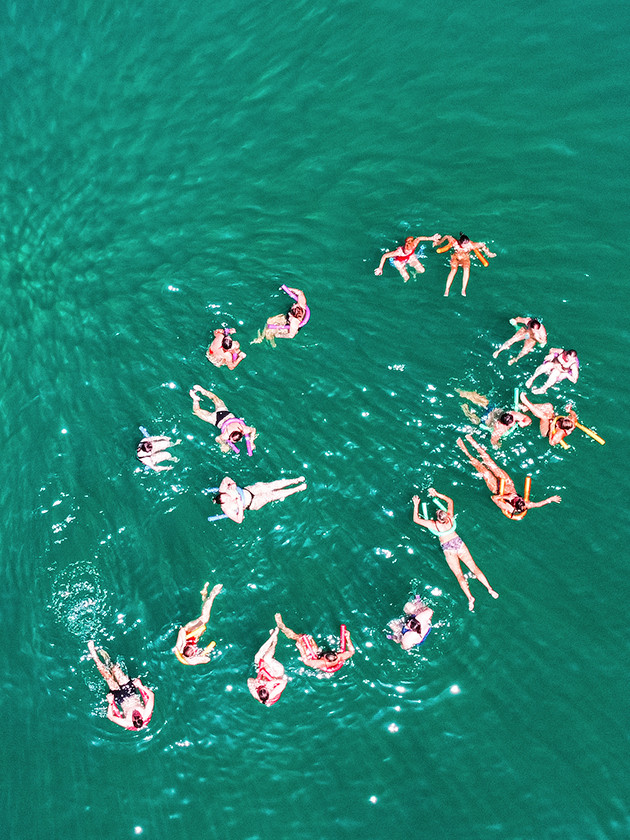 Topdeck travelers swimming in the crystal waters surrounding Lefkada in Greece.