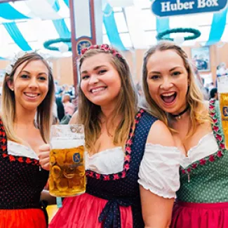 Three woman in traditional German dresses at Oktoberfest in Munich
