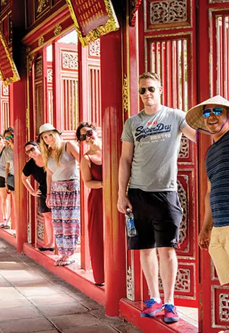 People standing in between pillars within a temple.