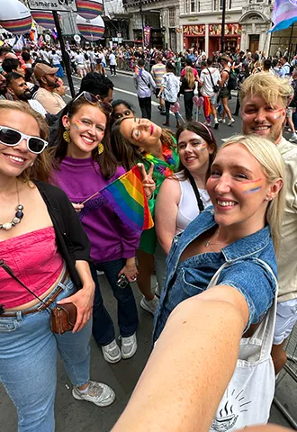 Group of people take a selfie wearing all different colours at the pride parade in London.
