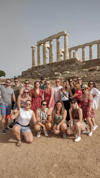 Group of people standing in front of the Temple of Poseidon.